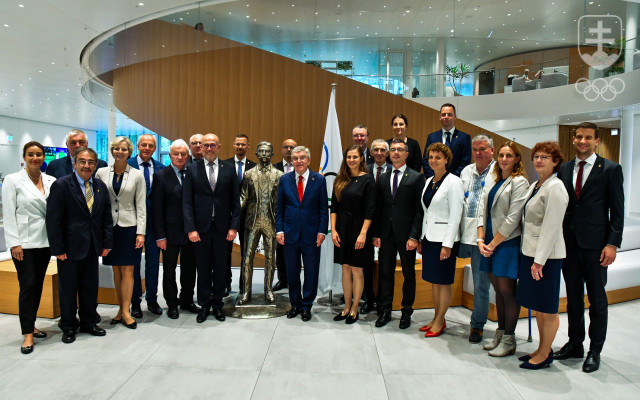 Delegácia SOŠV spoločne s prezidentom MOV Thomasom Bachom pri soche Pierra de Coubertin vo foyeri Olympijského domu v Lausanne.