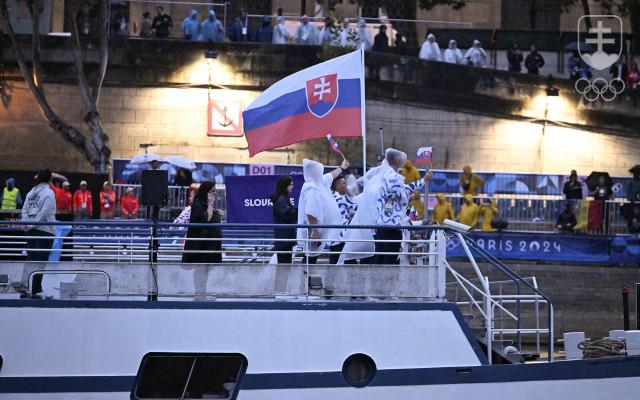 Vlajkonosiči slovenskej výpravy - vodní slalomári Jakub Grigar a Zuzana Paňková sa vezú na lodi po rieke Seina počas otváracieho ceremoniálu XXXIII. letných olympijských hier v Paríži 26. júla 2024. 