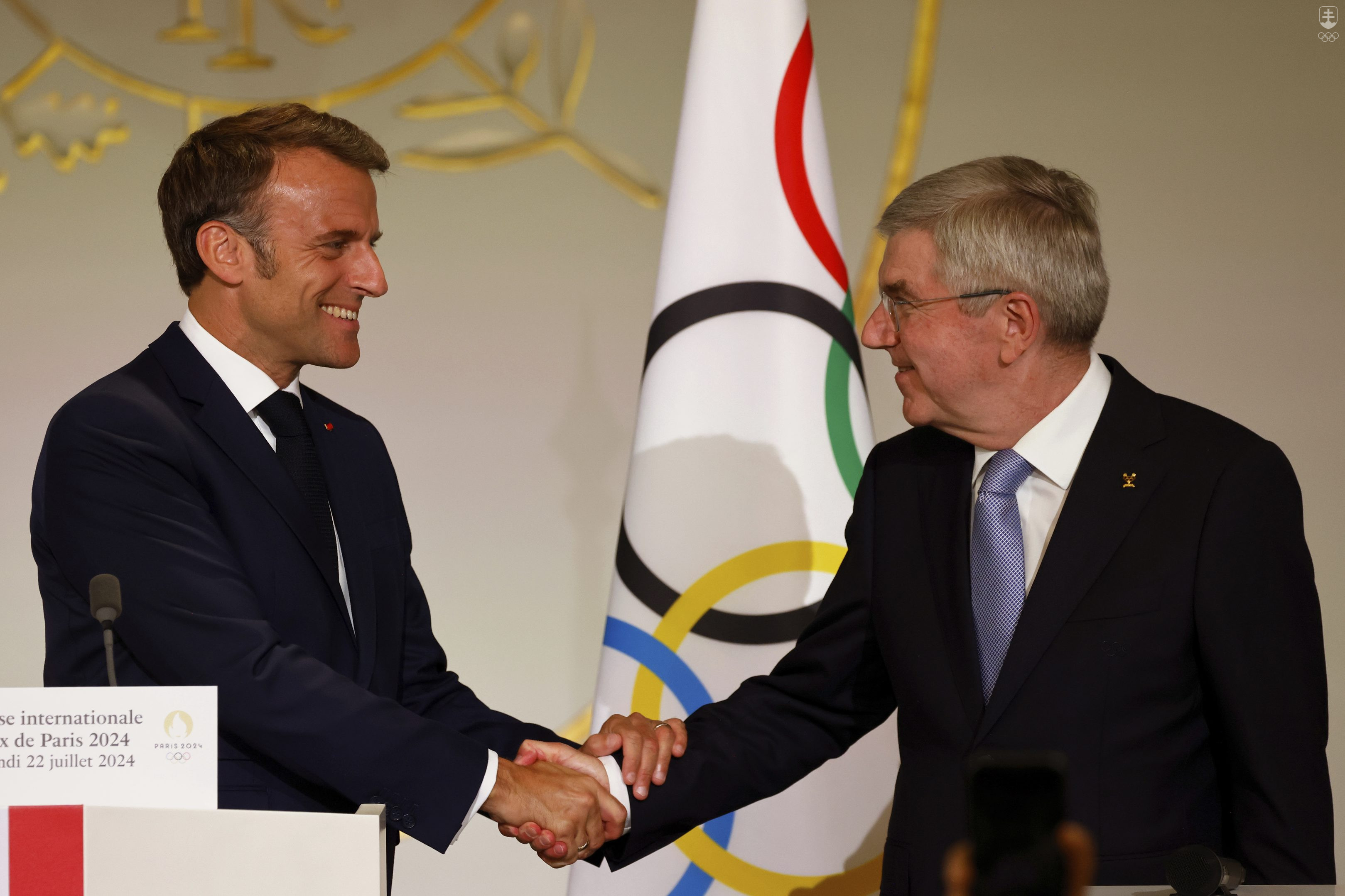 Prezidenti Francúzska a Medzinárodného olympijského výboru Emmanuel Macron a Thomas Bach sa zdravia počas recepcie pre médiá z celého sveta v Elyzejskom paláci